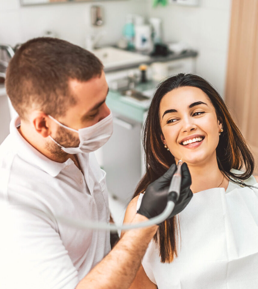Dentist working in dental clinic with patient in the chair