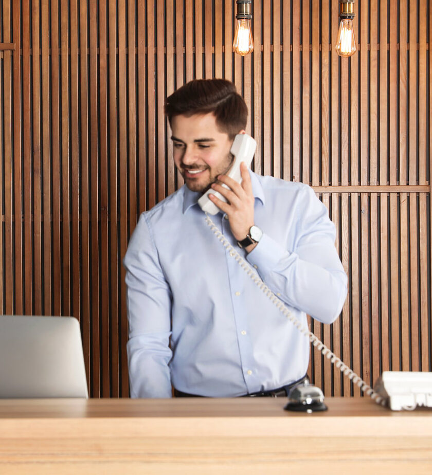 Receptionist talking on phone at desk in lobby
