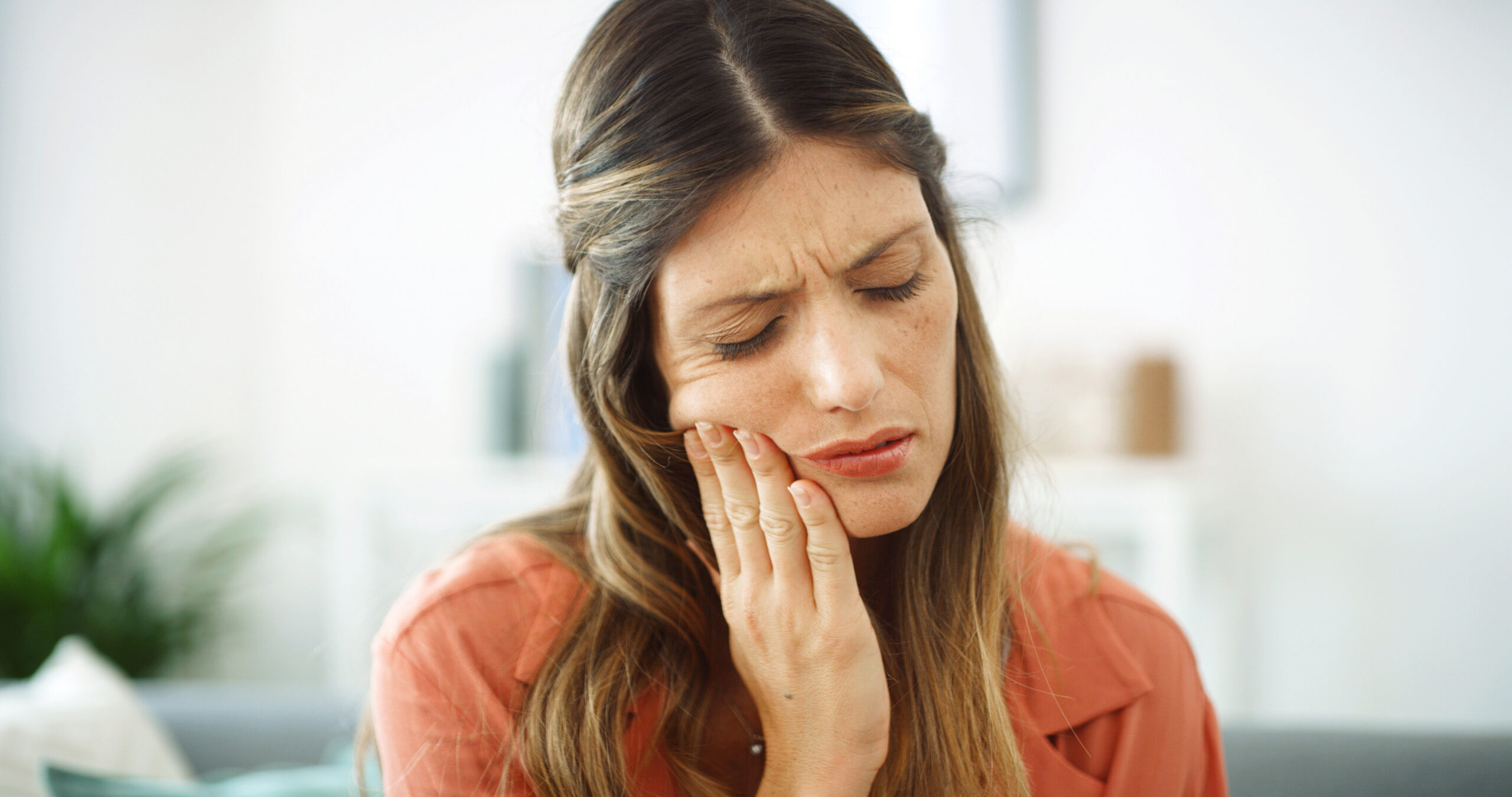 Woman, sore mouth and toothache at house from dental cavity, tooth extraction and gum infection. Female person, discomfort and oral decay with gingivitis, root canal injury and treatment for filling.