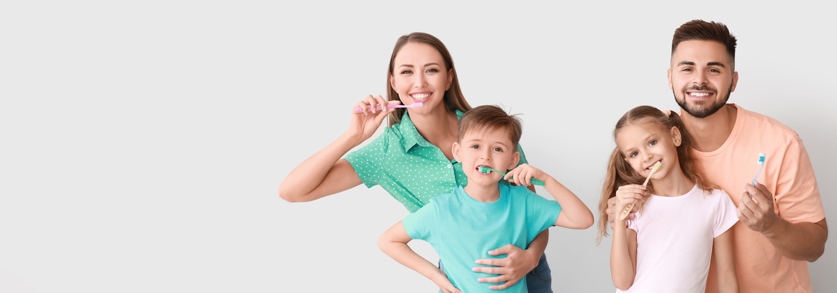 Portrait of happy family brushing teeth on light background with space for text