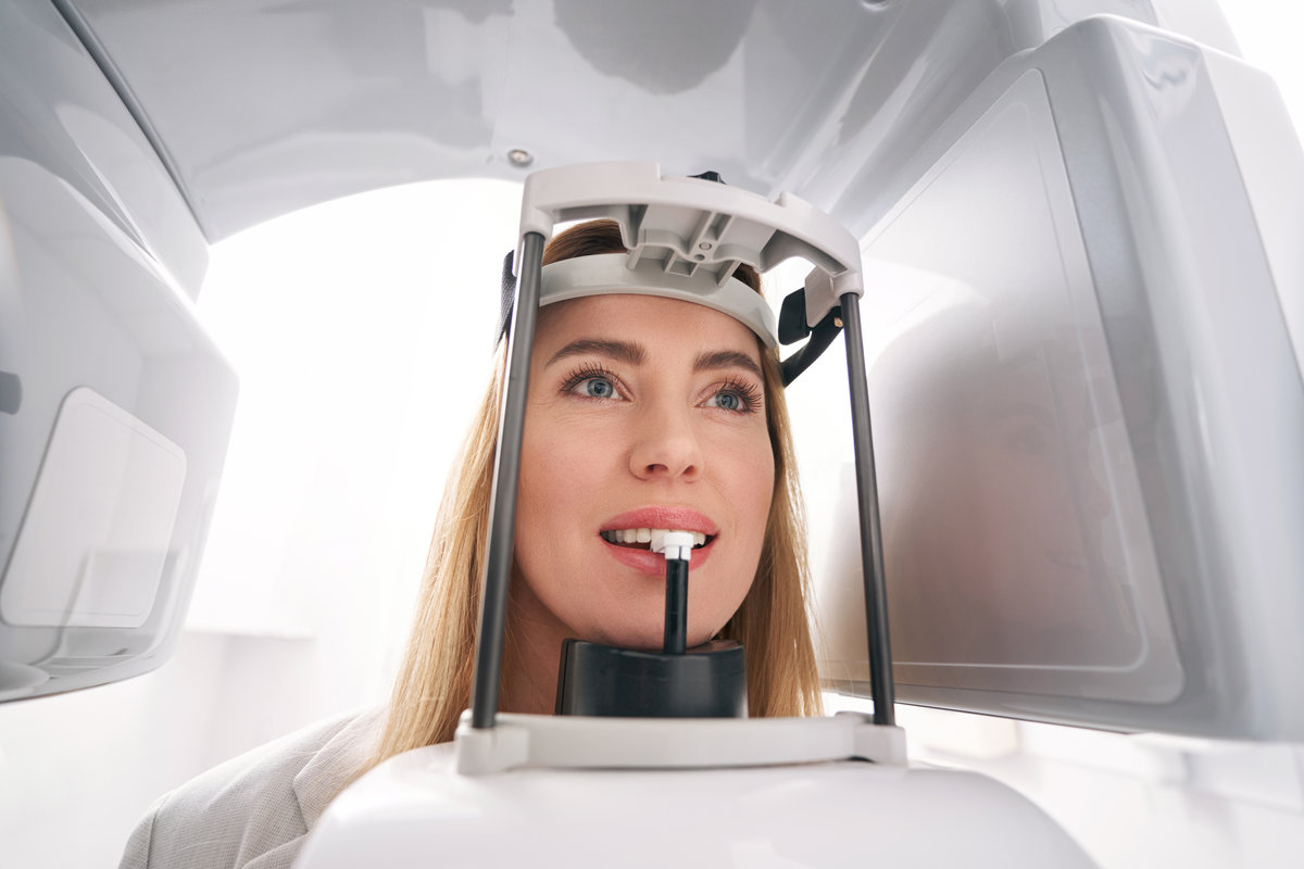 Female patient having teeth examination with modern dental diagnostic equipment