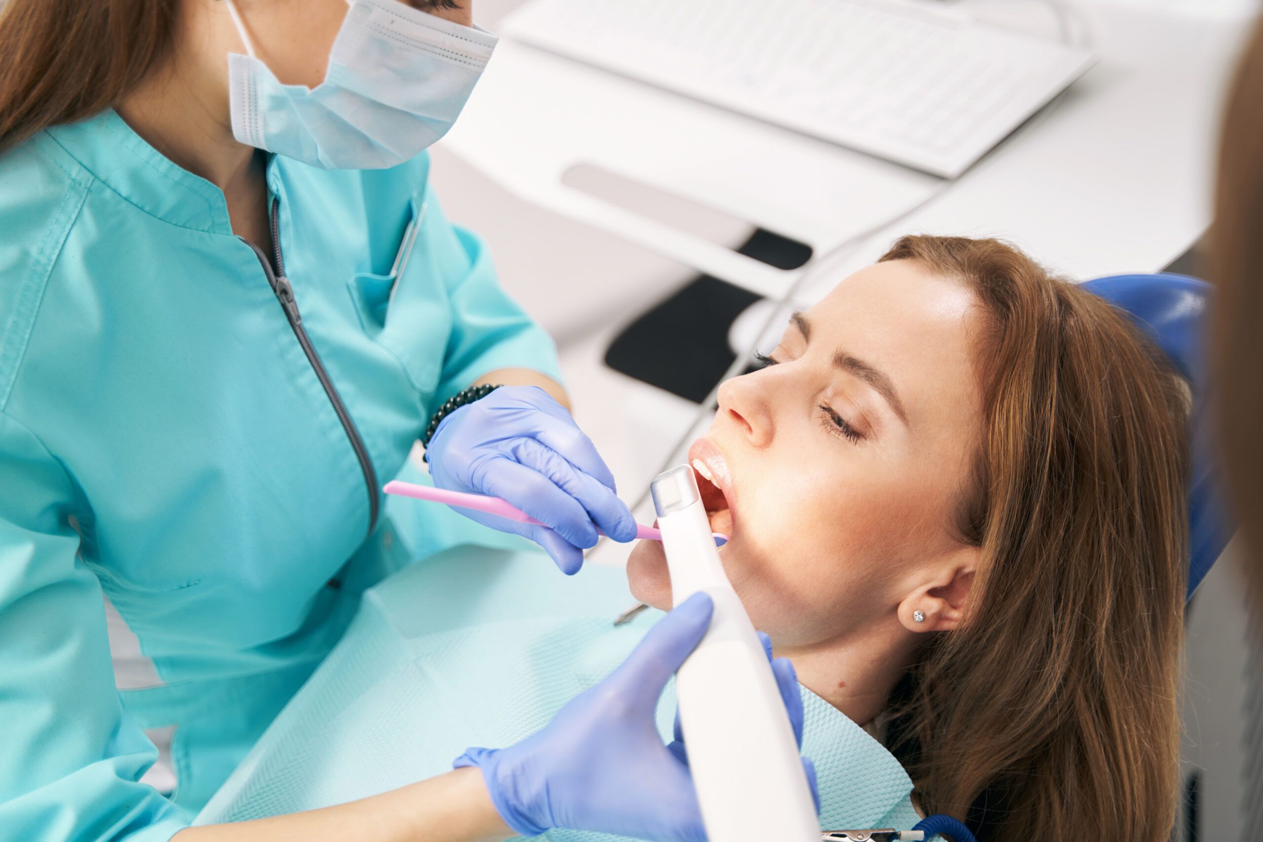 Dentist using a digital 3D scanner to capture a patient's teeth